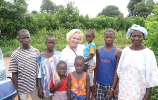 An image of Rita Wilkins, the "Downsizing Designer" in Africa experiencing life with locals.