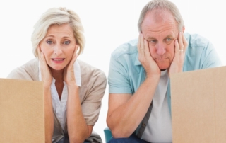 A couple in their 60s staring at cardboard boxes and getting started to declutter