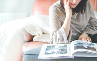 A woman looking at a photo album and preparing to declutter her home