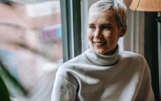 a Woman by a window realizing the benefits of downsizing and decluttering