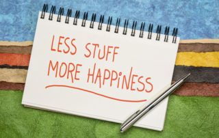 A notepad that says less stiff more happiness to inspire people to start decluttering