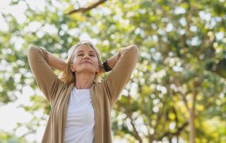 An image of a retired woman enjoying the breeze of the air as she transition to her new minimalist lifestyle.