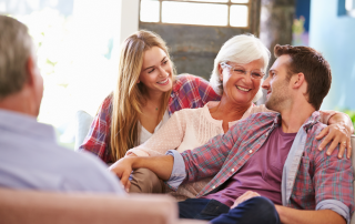 An image of adults kida and their parents having a couch conversation on how they can declutter and downsize their parents' house.
