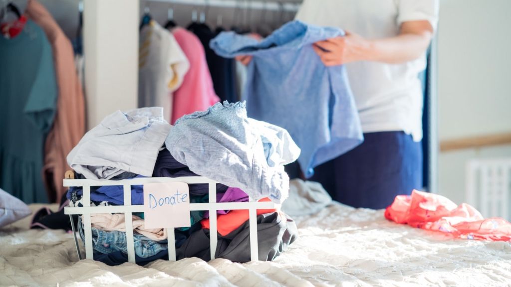 An image of a man trying to organize and declutter his closet.