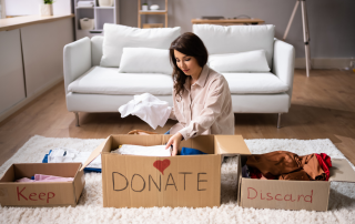 An image of a woman sorting and organizing her stuff for donation, keep and discard.