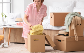 An image of a woman boxing all the items she wants to keep and donate while decluttering.