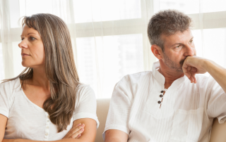 An image of a middle aged couple going through emotional challenges during downsizing and decluttering.