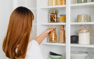 An image of a woman organizing her pantry and making sure she has a clear space for a clear mind.