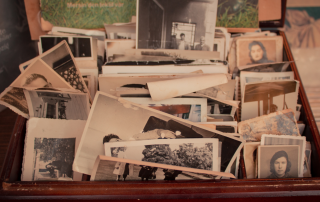 An image of a box full of old pictures found after decluttering their old parent's house.