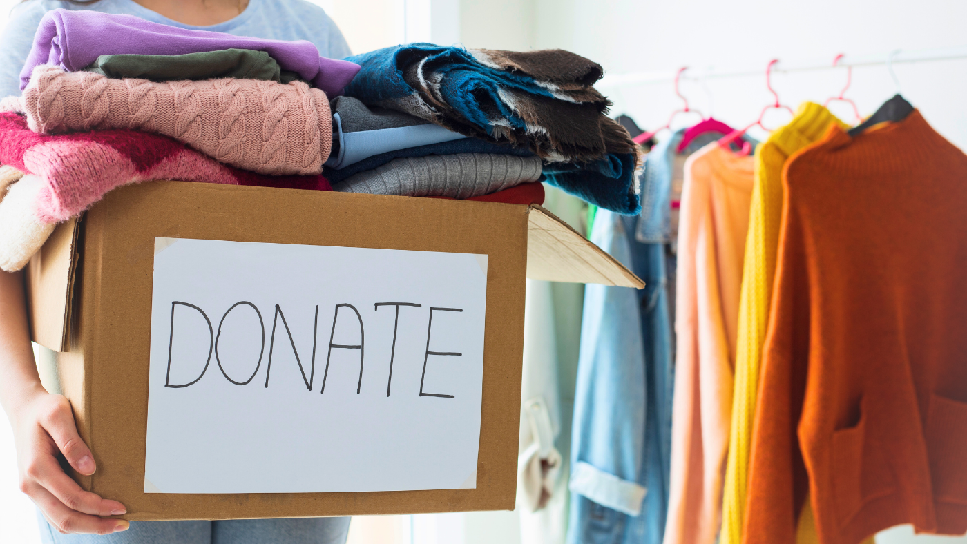An image of a person handing off a box full of old clothes for donation tat she initially was not ready to let go.
