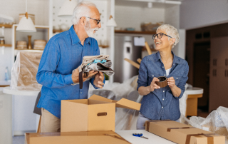 A senior couple sorting our items they have at their old big home getting ready to downsize and live their best lives.
