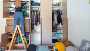 An image of a woman sorting the items in her closet making room for what truly matters.
