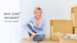 Woman sitting on the floor beside moving boxes in a bright, uncluttered room, symbolizing a fresh start and a new year commitment to decluttering and simplifying life.