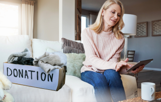Woman sitting on a couch with a tablet beside a donation box filled with clothing, reflecting on decluttering and letting go without regret.