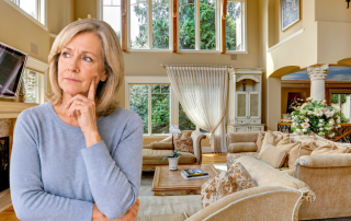Older woman looking thoughtful while standing in a large, elegant living room, reflecting on whether her home still fits her current stage of life.